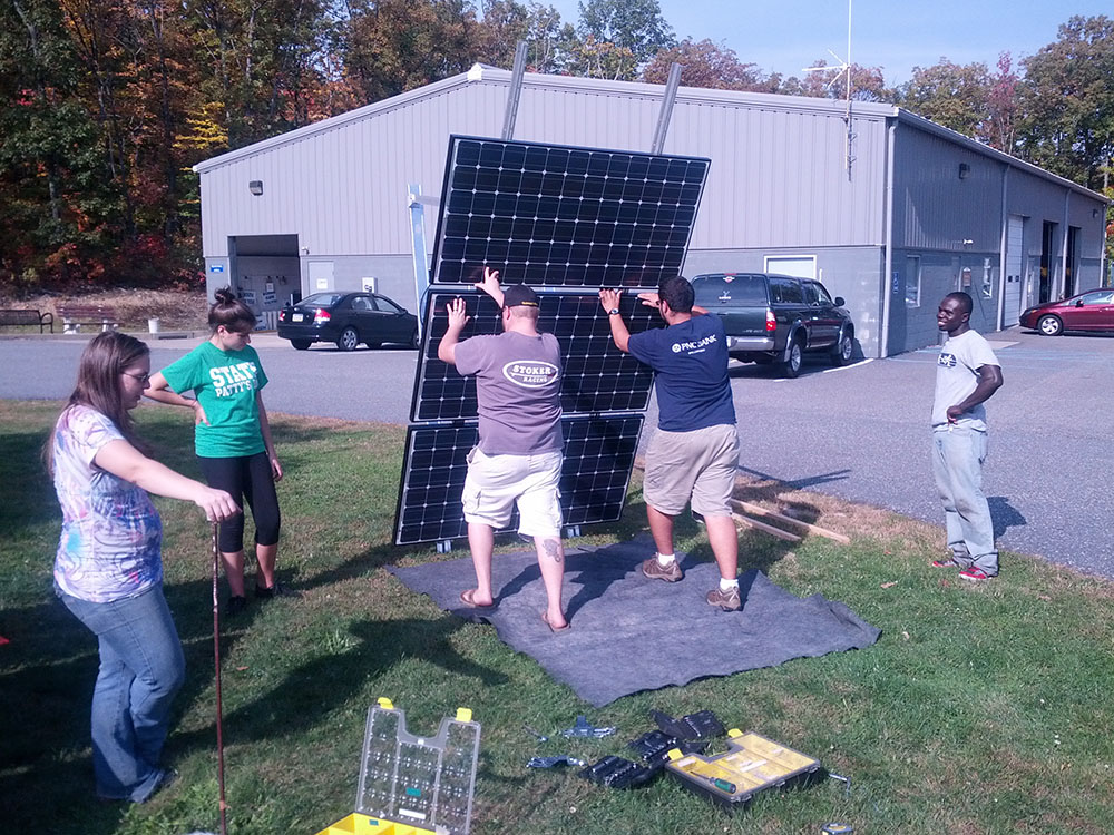 Engineering students install a solar panel.